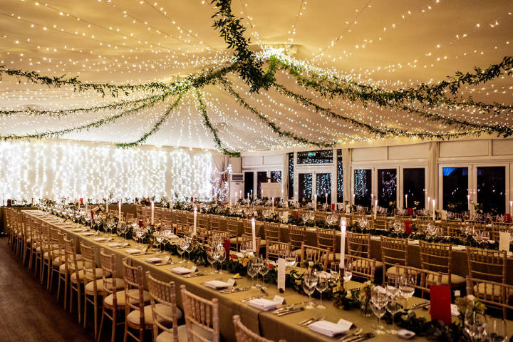 Marquee wedding featuring long tressel tables at Fulham Palace