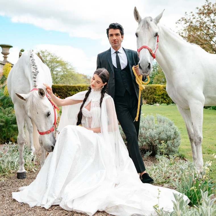 A bride & groom with their horses after the ceremony.