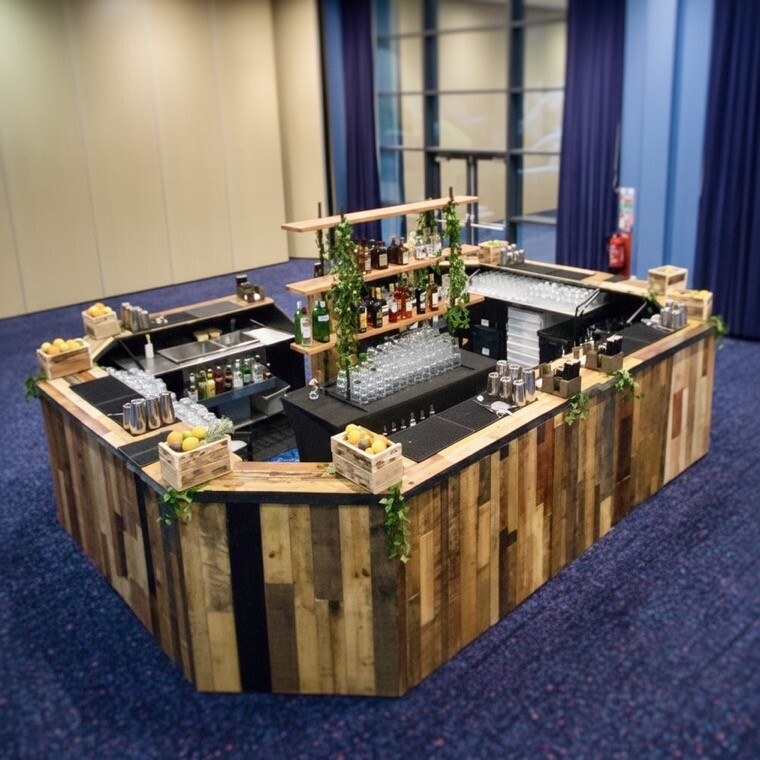 Cocktailhire wooden mobile bar with central bottle display at a UK event