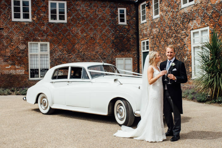 Bride and groom in front of wedding car at Fulham Palace
