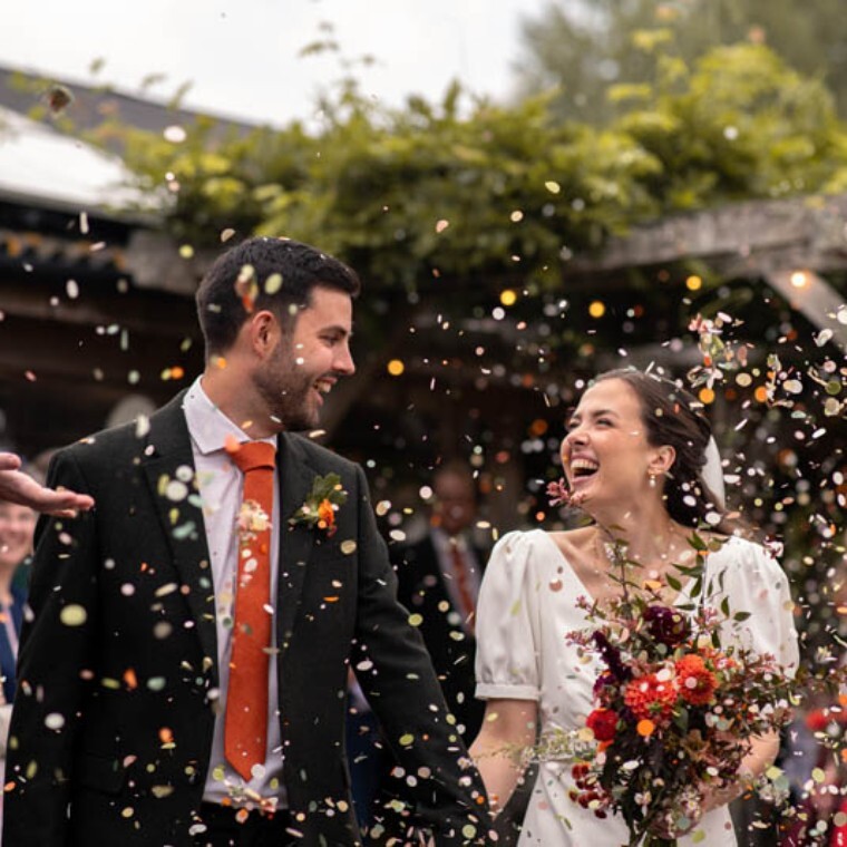Colourful confetti moment with autumn bride and groom.
