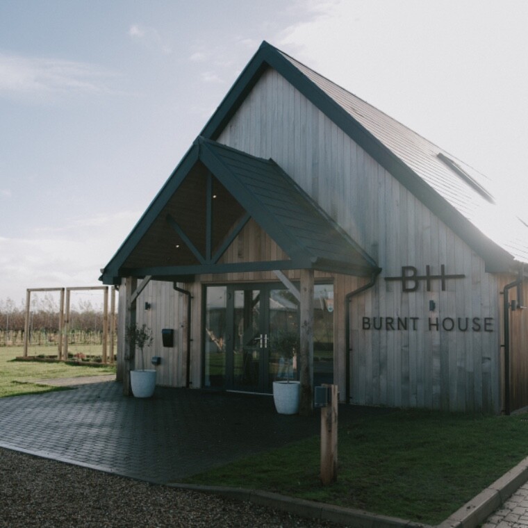 Burnt House Vineyard tasting room exterior in Suffolk, a modern winery building surrounded by vineyards, offering wine tastings, vineyard tours, events and countryside wedding venue views
