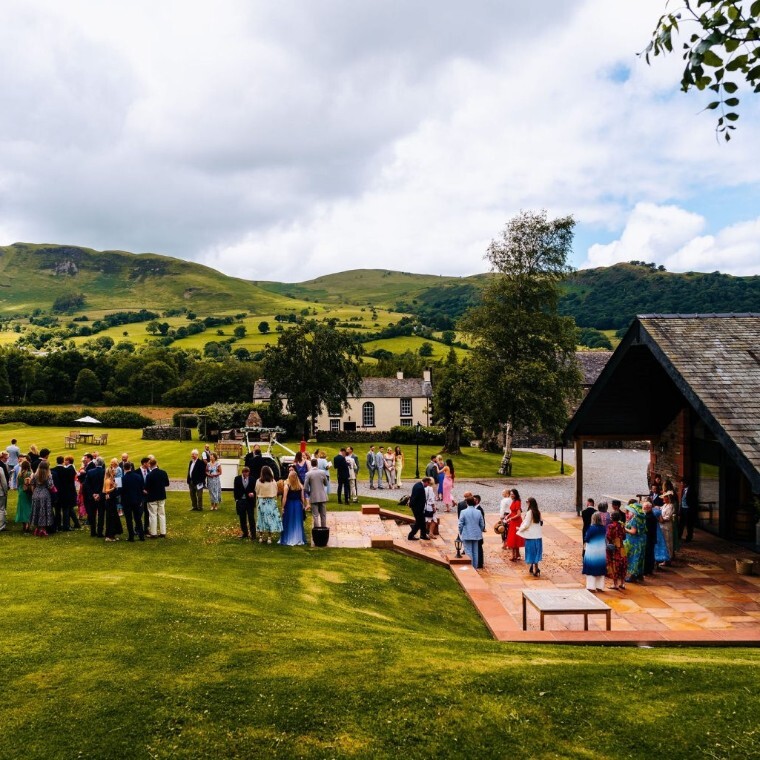 Wedding guests stood in the gardens at New House Farm Wedding Venue, Cumbria.