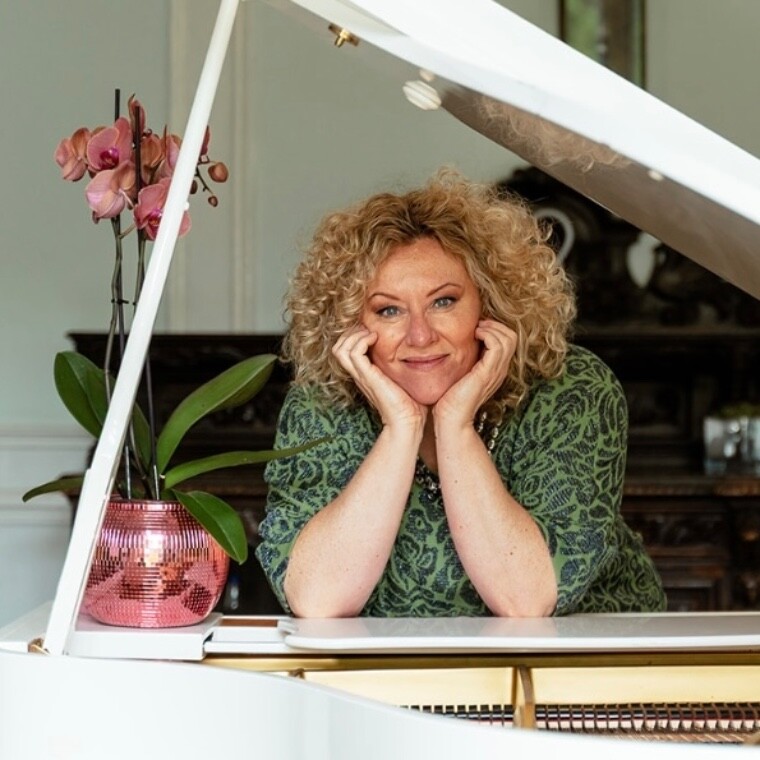 Pianist leaning on white baby grand