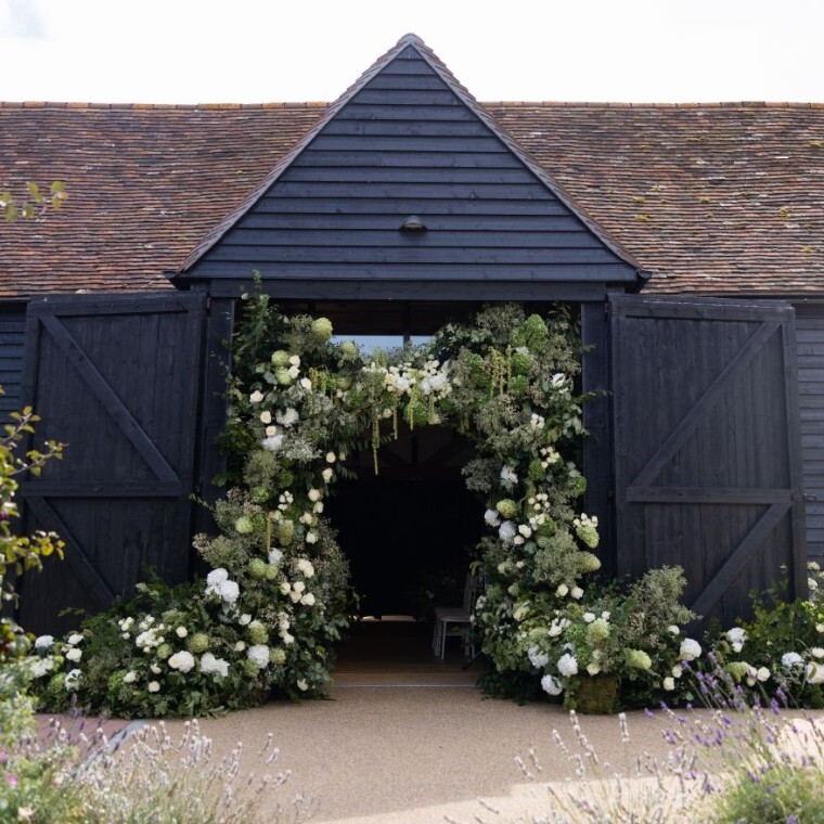 Front of barn with green and white flower garland