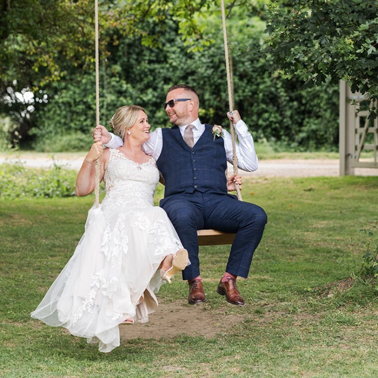 bride and groom sitting on swing at Houchins, Colchester