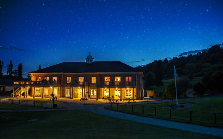 Woldingham clubhouse lit up at night
