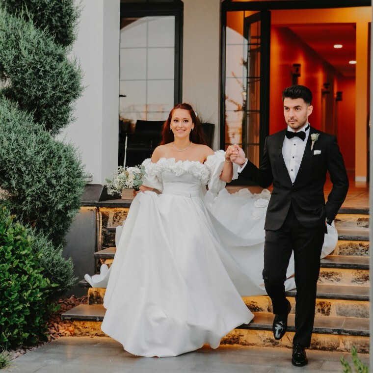 Bride and groom walk hand in hand outside of their wedding venue