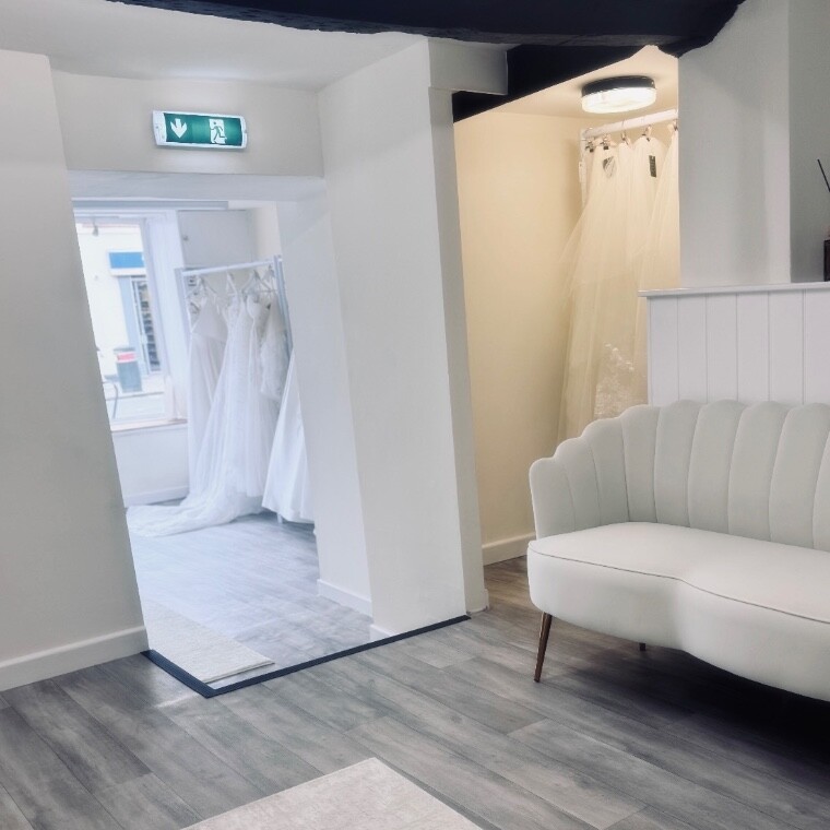 Interior of Audrée Rose bridal house in Cricklade, Wiltshire with private fitting space, luxury seating and wedding dresses on display.