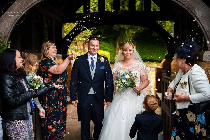 Bride and groom smiling as confetti is thrown over them