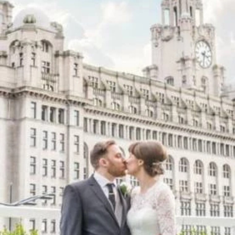 Bride and Groom kissing infront of large building