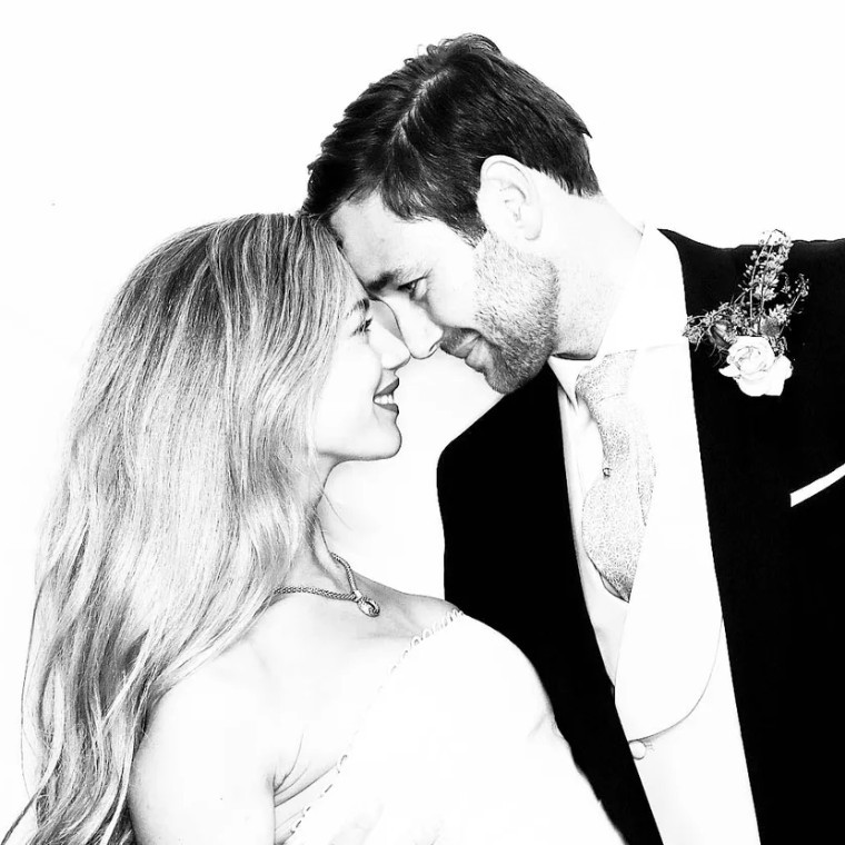 A Bride and Groom leaning in to each other whilst taking photos with the MooMuu Glam Booth 