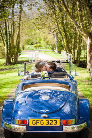 Bride and Groom in vintage car at Notley Abbey