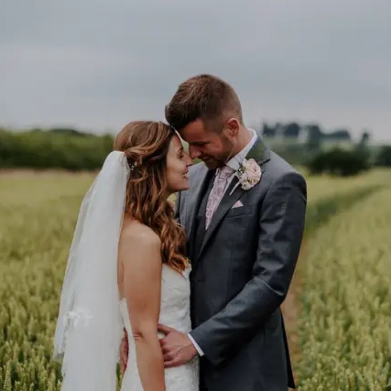 Bride and groom sharing a moment in a countryside field, captured by The Perfect Wedding Video, Buckinghamshire wedding videographers.