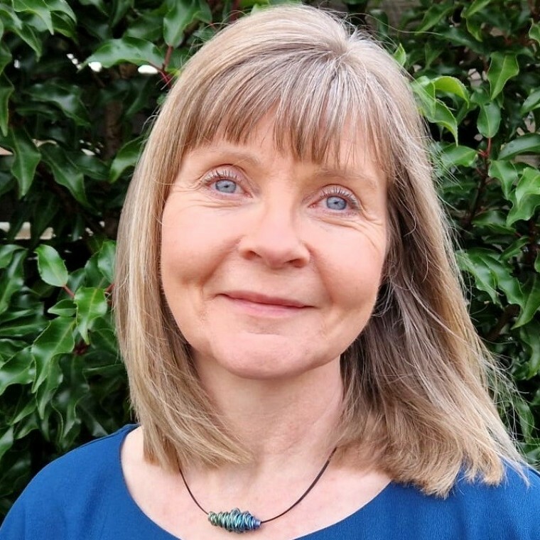 A head shot of a smiling female wedding celebrant