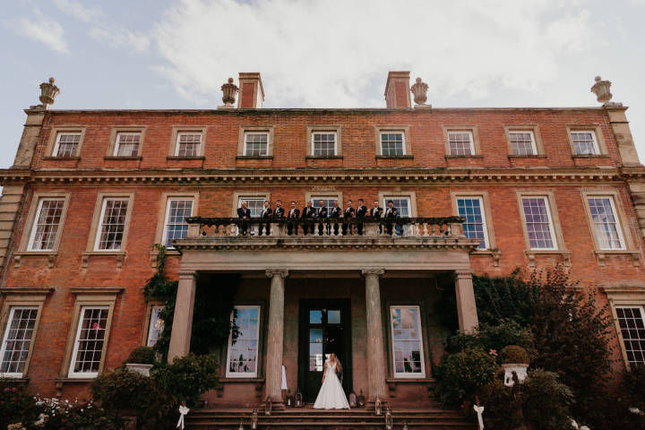 Bride and groom party on at the front of the house and on the balcony 