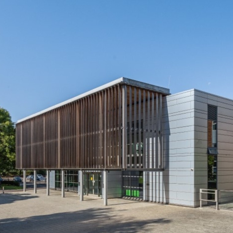Large modern building with grey cladding and wooden slats