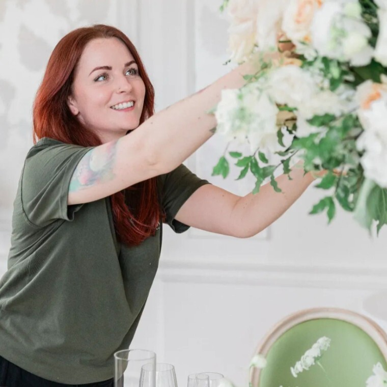 Florist setting up table flowers for a wedding