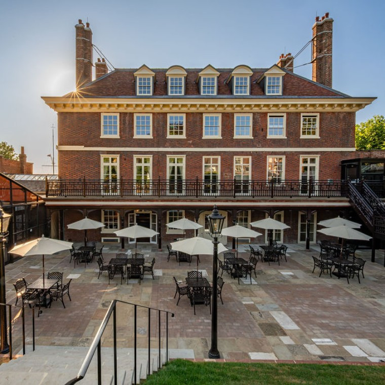 Exterior of a Queen Anne style Georgian mansion wedding venue at sunset with a view of the terrace