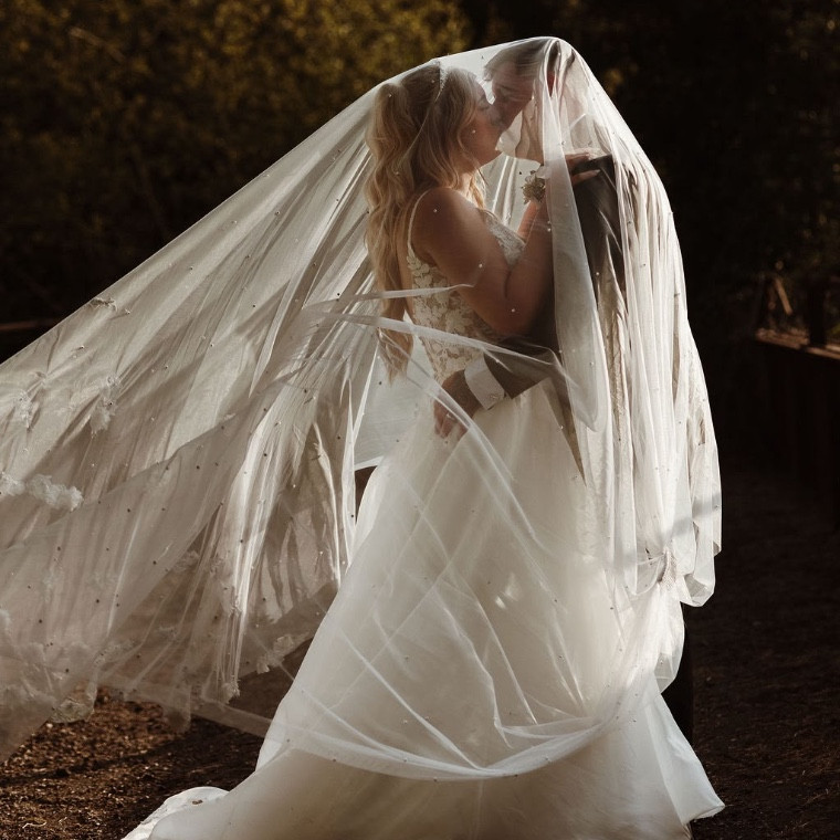 Bride and groom at sunset under the veil