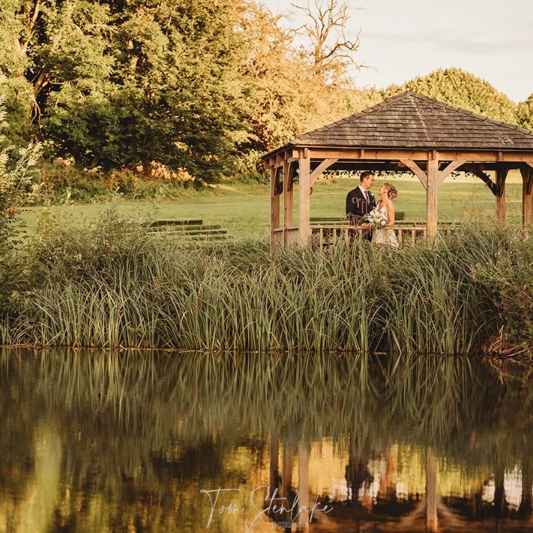 Bride and groom on gazebo by the lake