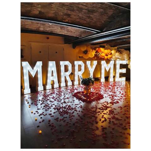 Large illuminated letters spelling Marry Me