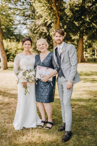 Celebrant with Couple under Tree after outdoor wedding ceremony at National Trust property Hartley Wintney