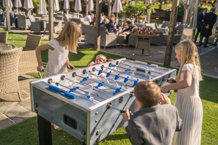 Children playing table football at a wedding at The Bear of Rodborough Hotel in Gloucestershire