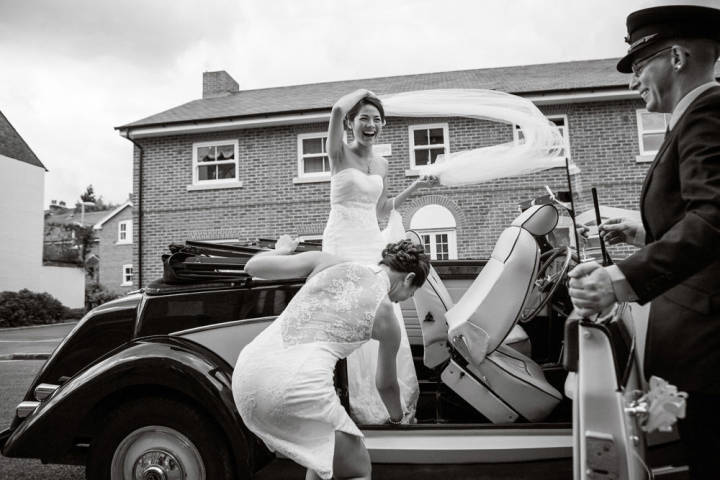 Veil blowing in the wind bride standing in car