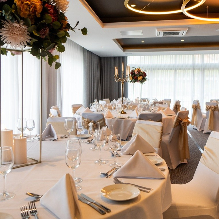 Holiday Inn Nottingham wedding reception in the Marina Suite, beautifully dressed with elegant tables, floral centrepieces and gold chair sashes.