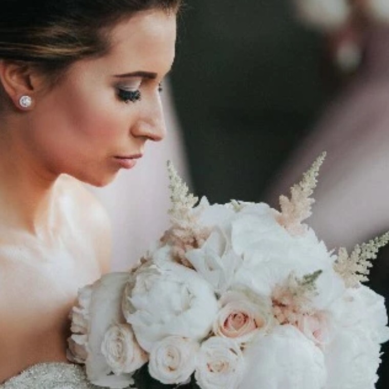 Bride looking down at white flowers from Sonning Flowers florist
