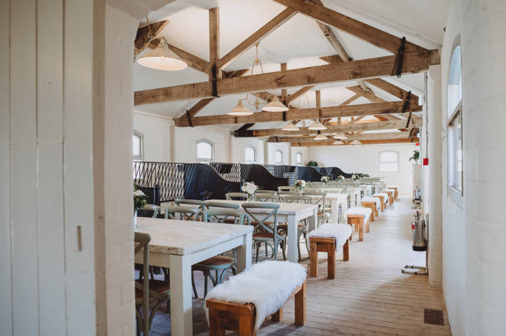 Large renovated barn dining room with tables, chairs and benches 
