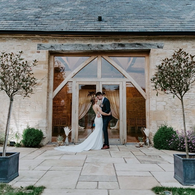 Bride and Groom hugging outside The Barn at Upcote Wedding Venue 