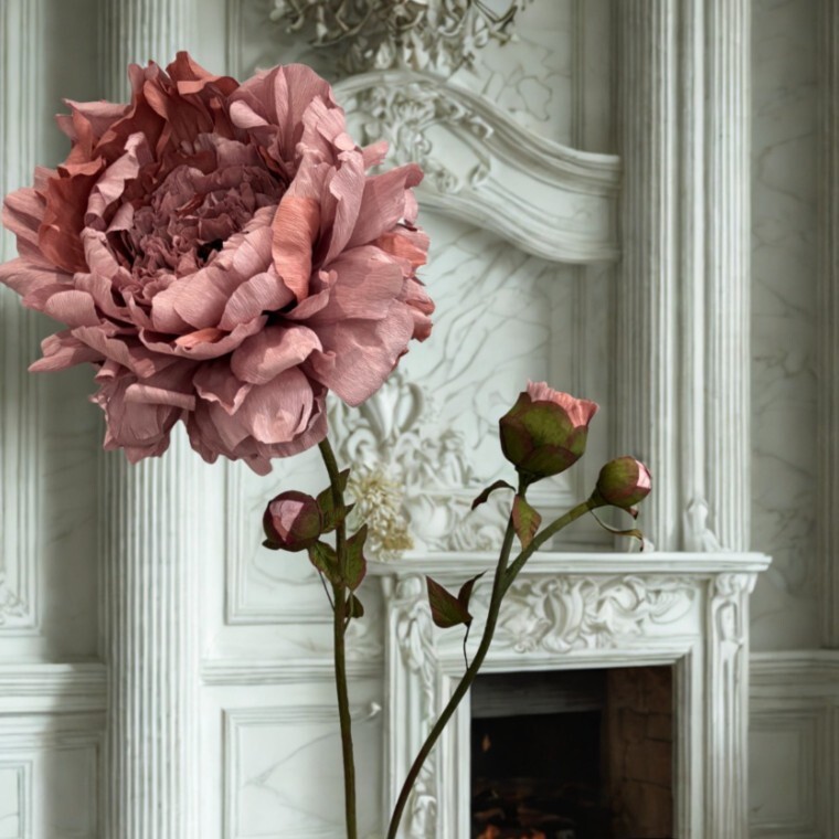 Large crepe paper Peony in front of the fireplace at a wedding venue by Capehorn Creative