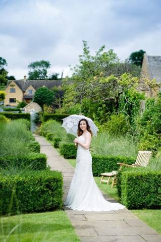 Bride Holding Parasole in Gardens of Cotswold House Hotel and Spa, Venues in Chipping Campden, Gloucestershire