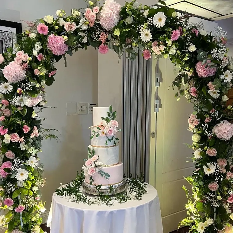 This elegant 4 tier fondant cake was perfectly finished with the most beautiful hand crafted sugar flowers and foliage that blend perfectly with the flower arch created by @petalsofwalton 