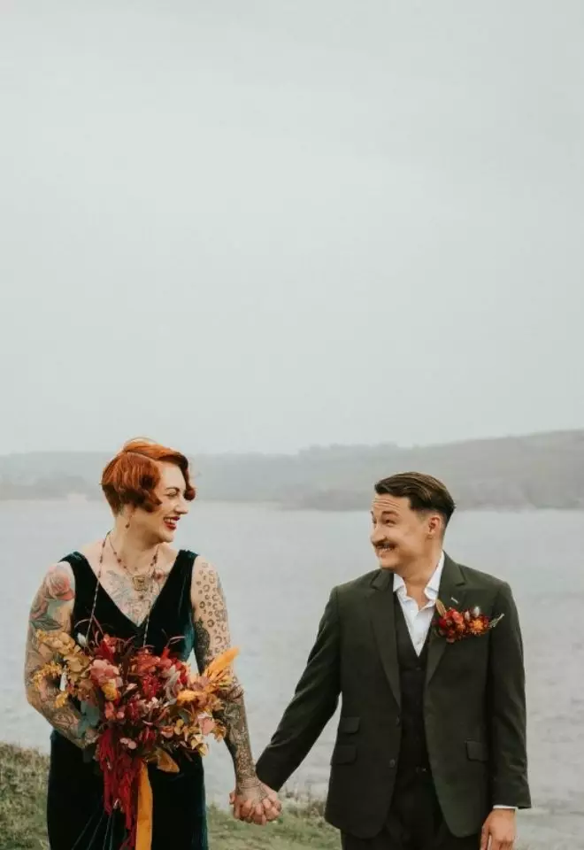 Couple in a green suit and dress on top of a cliff
