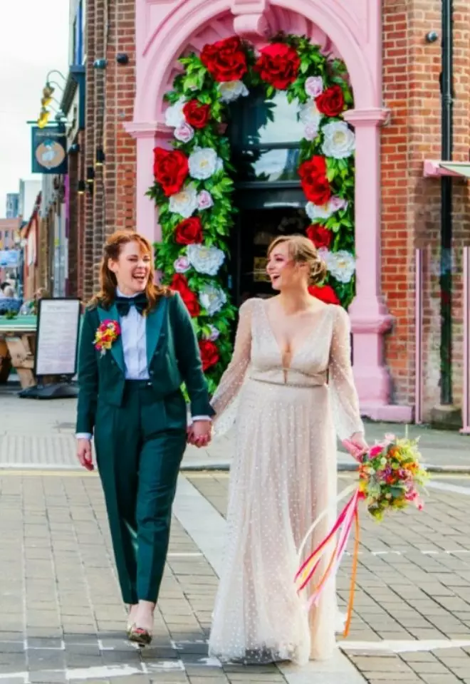 Two women walking holding hands 